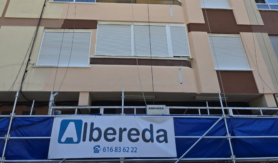 Andamio delante de una fachada con cartel de Albereda y el teléfono de la empresa