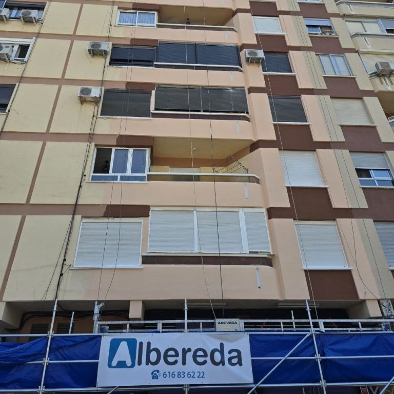 Fachada de edificio en rehabilitación con andamio y el cartel de Albereda
